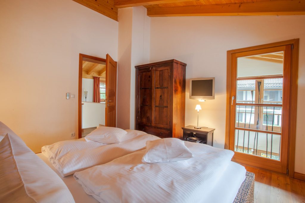 Doppelbett mit kleinem Fernseher in Ferienwohnung in Garmisch-Partenkirchen