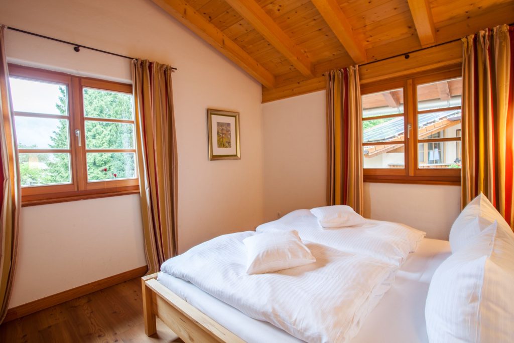 Doppelbett und Gardinen in Ferienwohnung in Garmisch-Partenkirchen