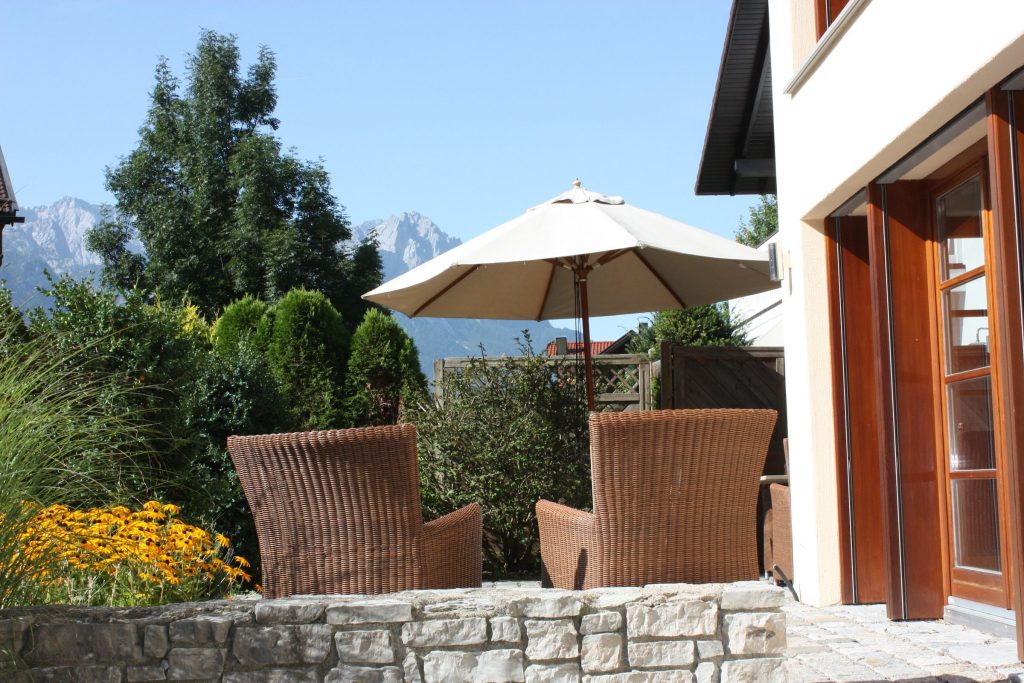 Terrasse mit Stühlen und Sonnenschirm in Ferienwohnung in Garmisch-Partenkirchen