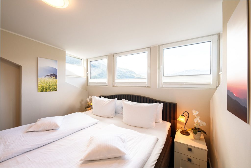 Doppelbett mit drei Fenster in Ferienwohnung in Garmisch-Partenkirchen