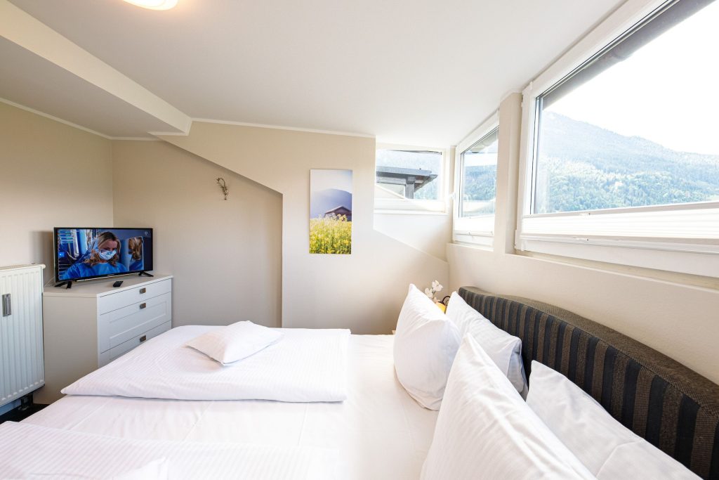 Doppelbett und Fernseher in Ferienwohnung in Garmisch-Partenkirchen