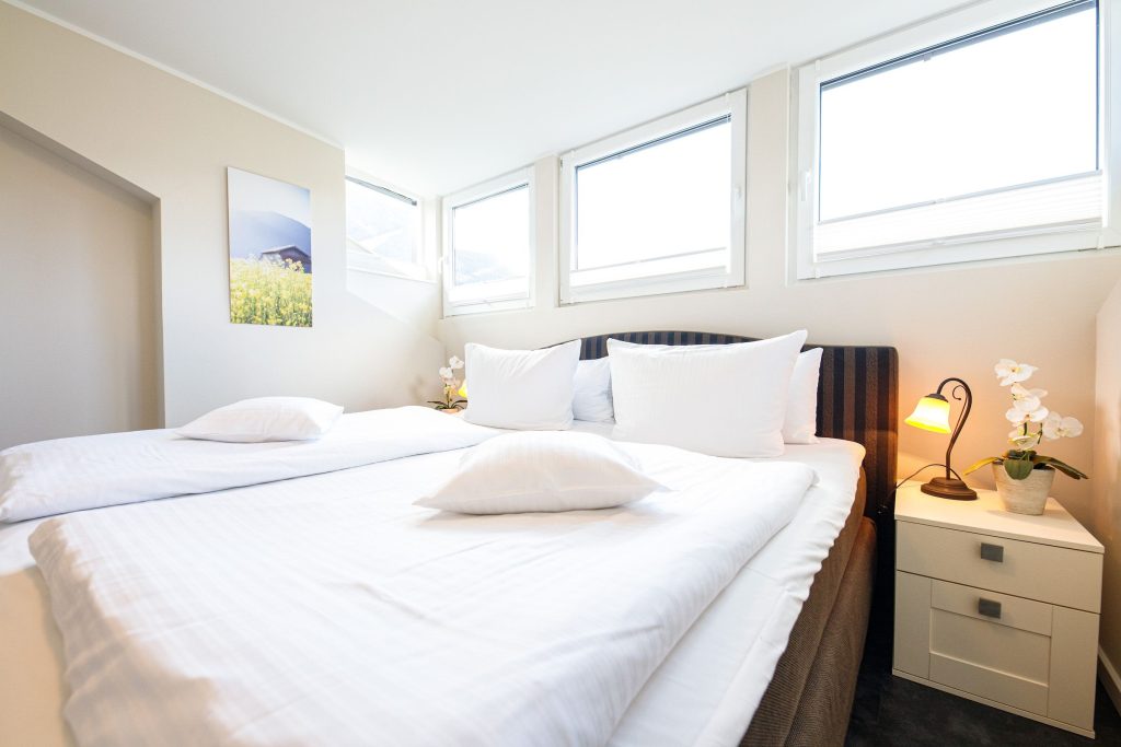 Doppelbett mit Nachttisch in Ferienwohnung in Garmisch-Partenkirchen