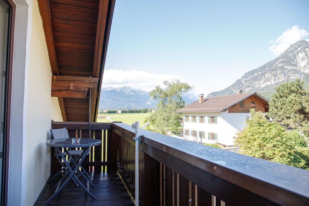 Balkon mit Stühlen und Tisch in Ferienwohnung in Garmisch-Partenkirchen