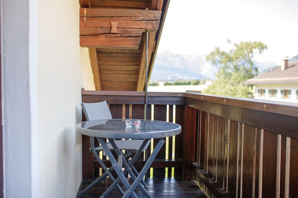 Balkon mit Stuhl und Tisch in Ferienwohnung in Garmisch-Partenkirchen