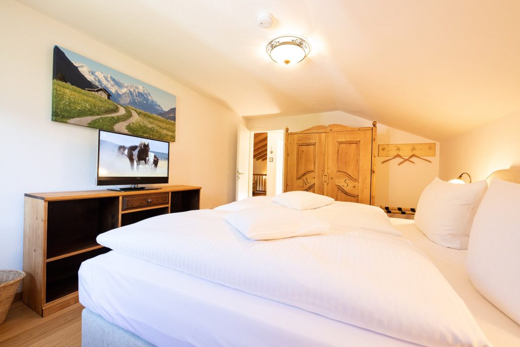 Doppelbett mit Fernseher in Ferienwohnung in Garmisch-Partenkirchen