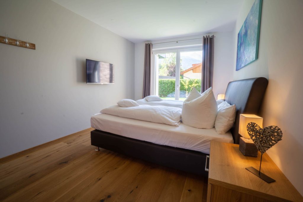 Doppelbett mit Nachttisch in Ferienwohnung in Garmisch-Partenkirchen