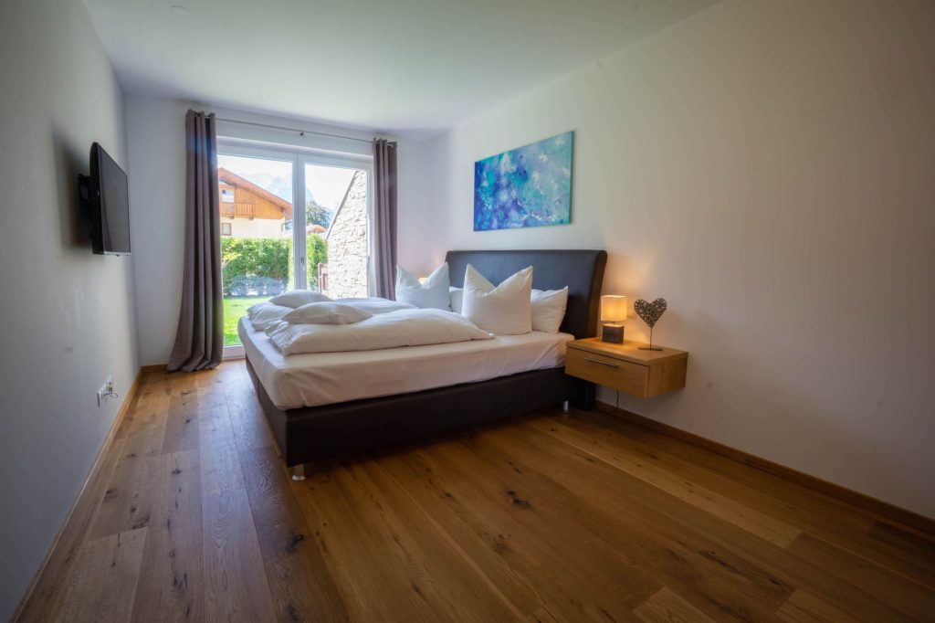 Doppelbett mit Fernseher in Ferienwohnung in Garmisch-Partenkirchen