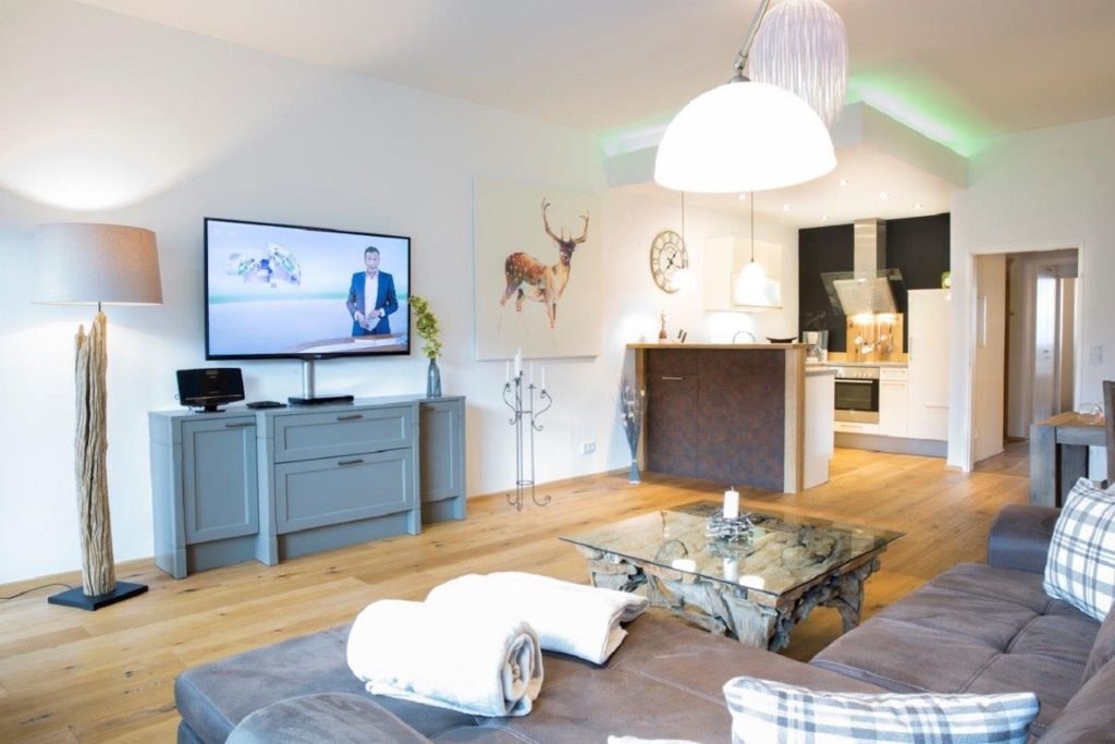 Wohnzimmer mit Sofa und Fernseher in Ferienwohnung in Garmisch-Partenkirchen