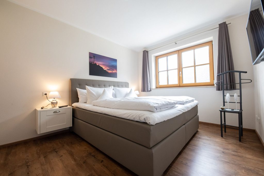 Doppelbett mit Fenster in Ferienwohnung in Garmisch-Partenkirchen