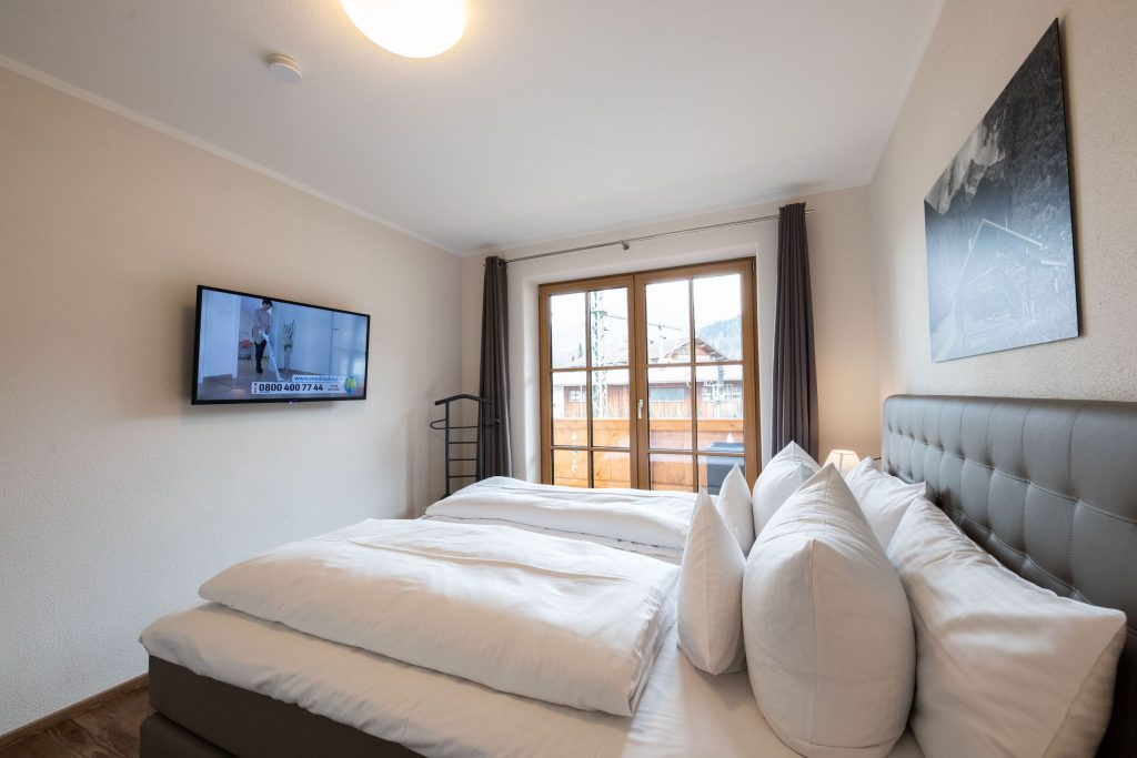 Doppelbett mit Fernseher in Ferienwohnung in Garmisch-Partenkirchen