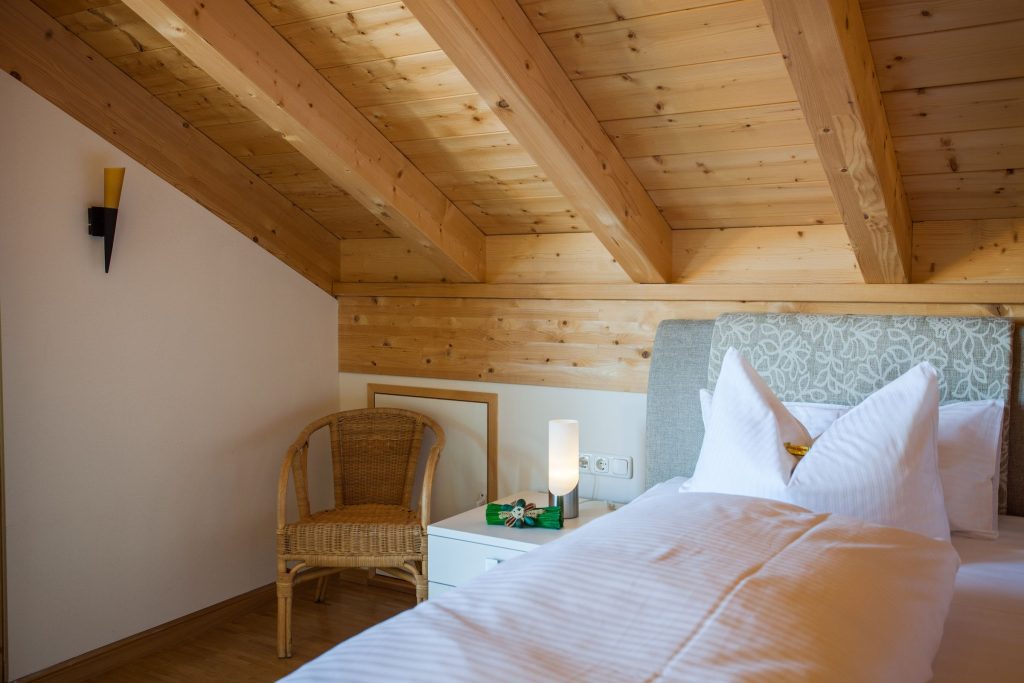 Einzelbett mit Sitzmöglichkeit und Nachttisch in Ferienwohnung in Garmisch-Partenkirchen