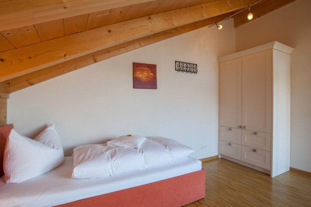 Einzelbett und weißer Kleiderschrank in Ferienwohnung in Garmisch-Partenkirchen