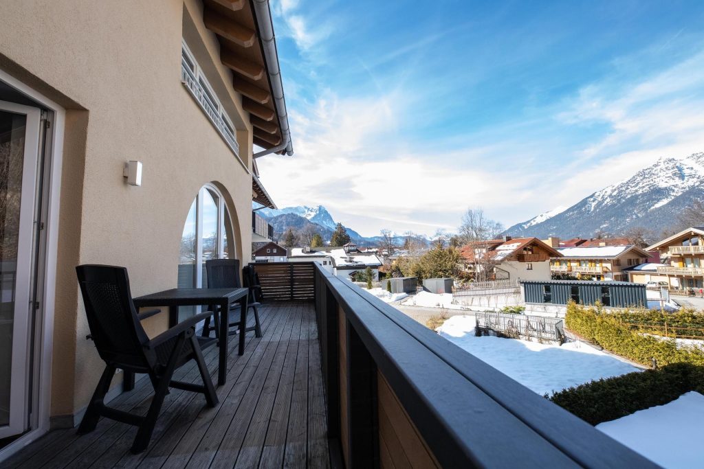 Balkon mit Aussicht auf die Berge und Sitzmöglichkeiten mit einem kleinen Tisch in Ferienwohnung in Garmisch-Partenkirchen