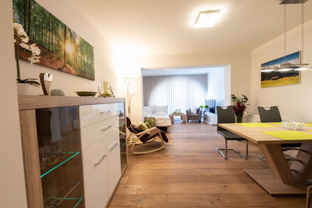 Offener Wohnbereich mit Esstisch und Schlafsofa mit Fernsehen in Ferienwohnung in Garmisch-Partenkirchen