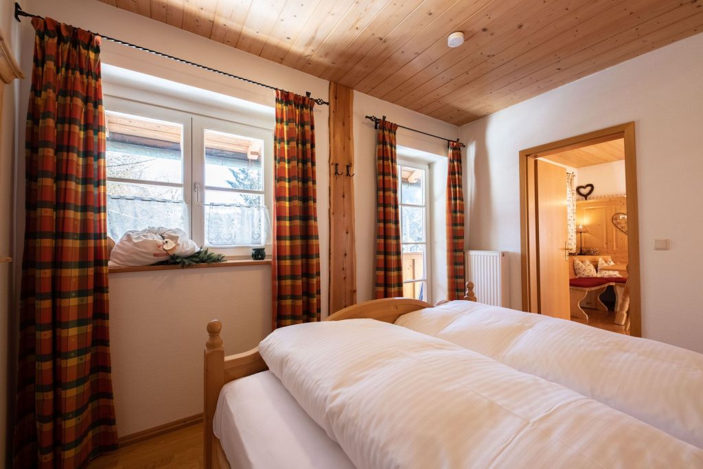 Doppelbett und Fenster in Ferienwohnung in Garmisch-Partenkirchen