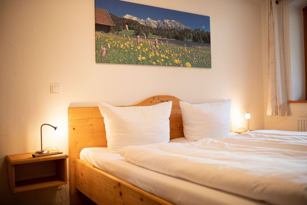 Doppelbett mit Nachttisch in Ferienwohnung in Garmisch-Partenkirchen