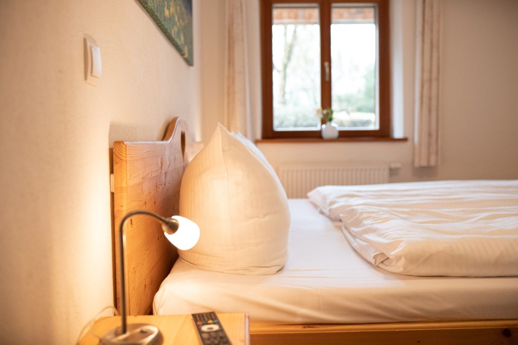 Doppelbett mit Nachttisch und Lampe in Ferienwohnung in Garmisch-Partenkirchen