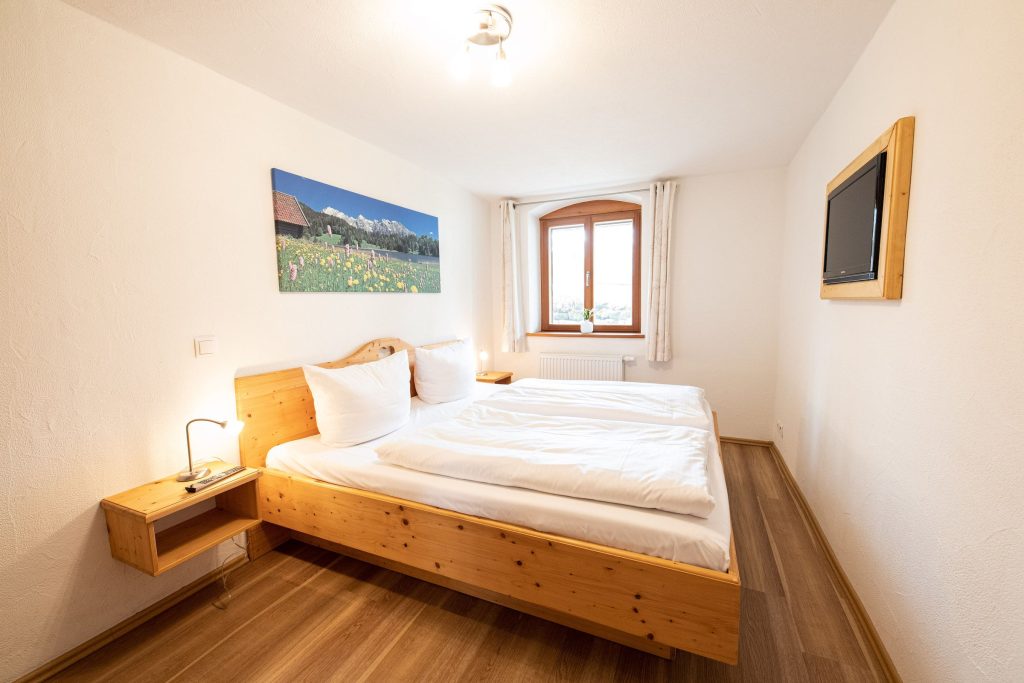 Doppelbett mit Holz Nachttisch in Ferienwohnung in Garmisch-Partenkirchen