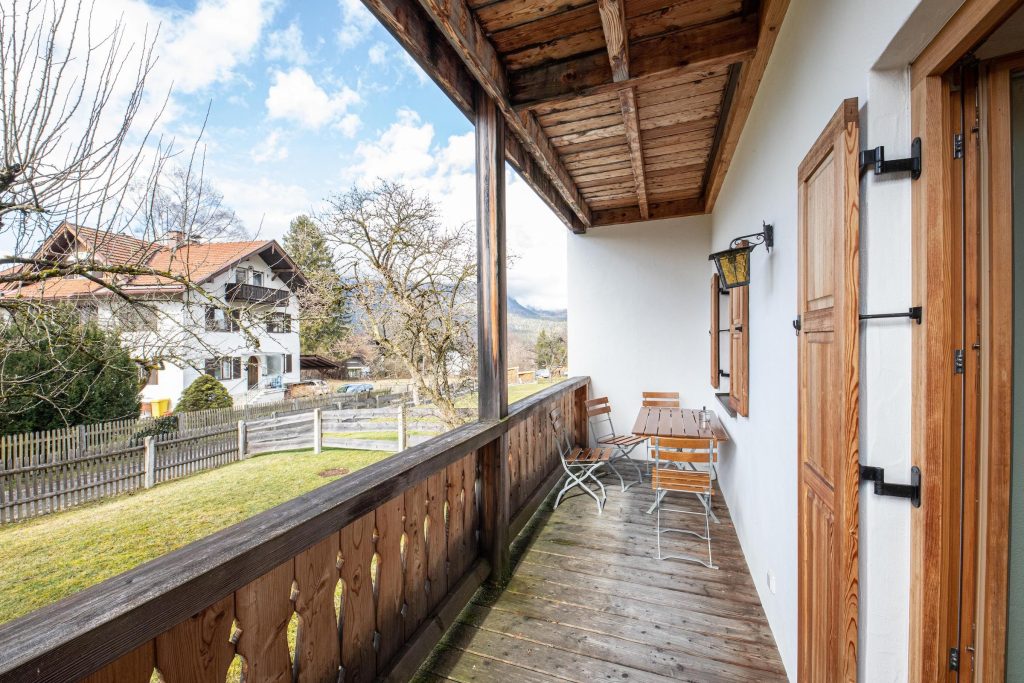 Balkon mit Stühlen und einem kleinen Tisch in Ferienwohnung in Garmisch-Partenkirchen