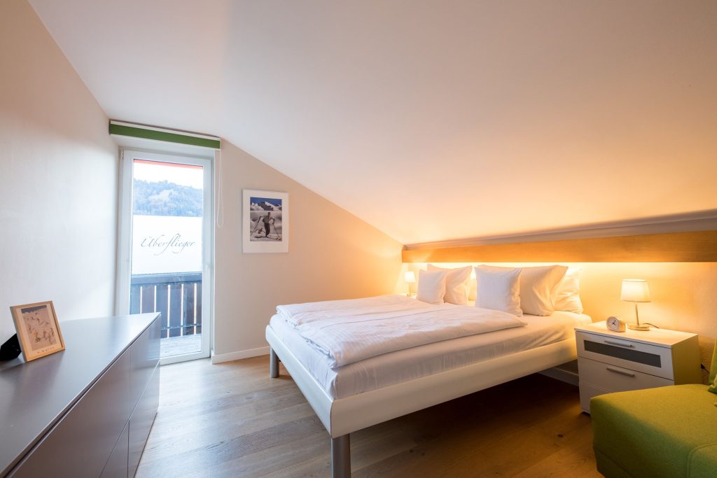 Schlafzimmer mit Bett und Ski Bildern in Ferienwohnung in Garmisch-Partenkirchen