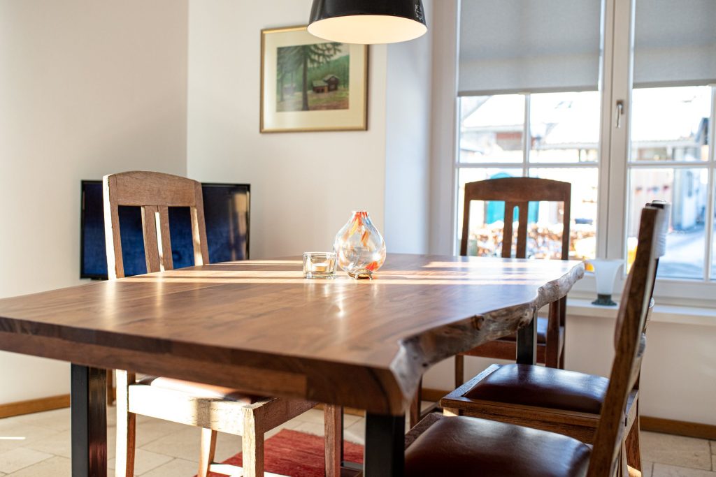 Esstisch in dunkler Holz-Optik mit dunklen Holz Stühlen und einer Vase in Ferienwohnung in Garmisch-Partenkirchen