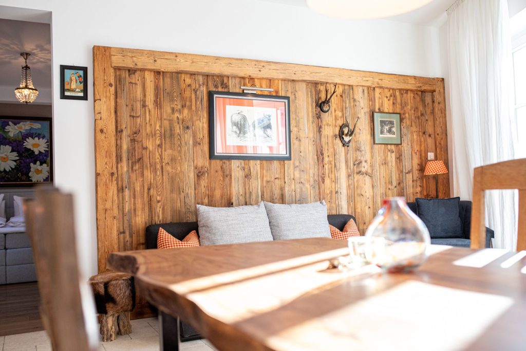 Holzwand mit Bildern und kleines dunkel graues Sofa in Ferienwohnung in Garmisch-Partenkirchen