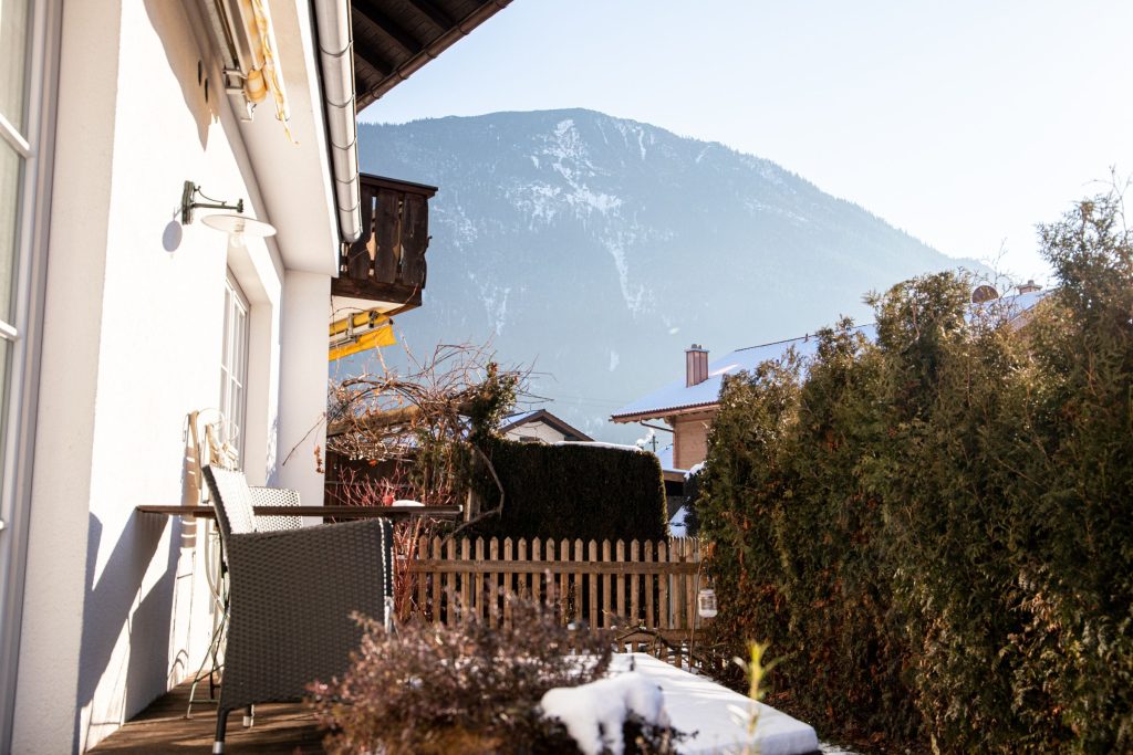 Terrasse mit zwei Stühlen und einem kleinen Tisch in Ferienwohnung in Garmisch-Partenkirchen 