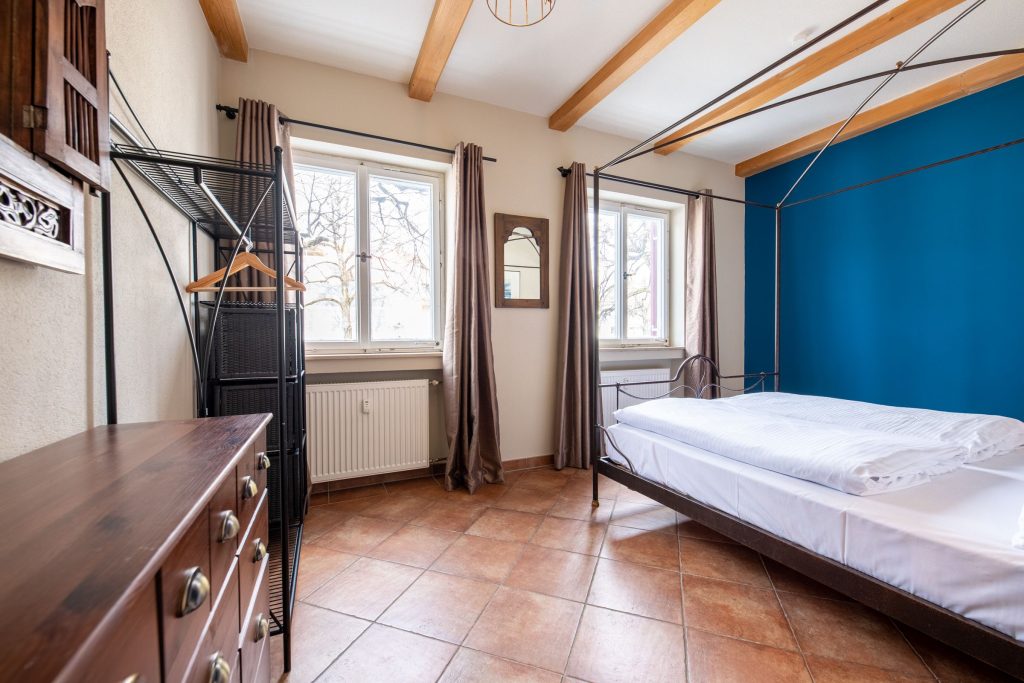 Schlafzimmer mit Fliesen und blauer Wand in Ferienwohnung in Garmisch-Partenkirchen