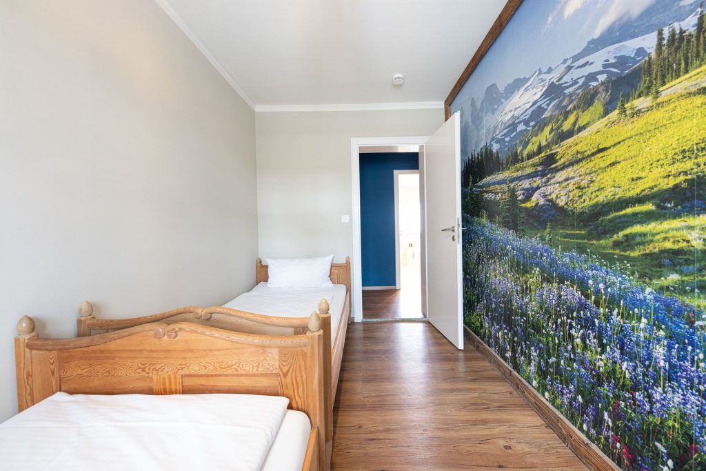 Zimmer mit zwei Betten und einer Landschaftstapete  in Ferienwohnung in Garmisch-Partenkirchen