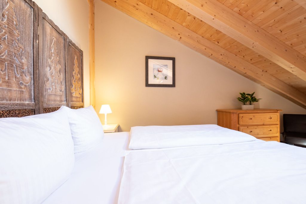 Doppelbett mit einer Schräge in Ferienwohnung in Garmisch-Partenkirchen