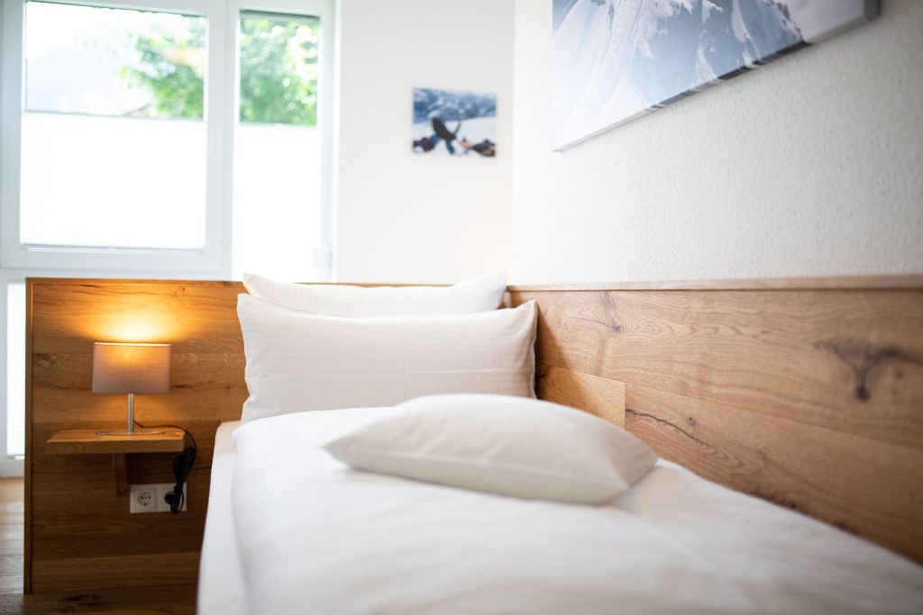 Bett mit einer Nachttischlampe  in Ferienwohnung in Garmisch-Partenkirchen