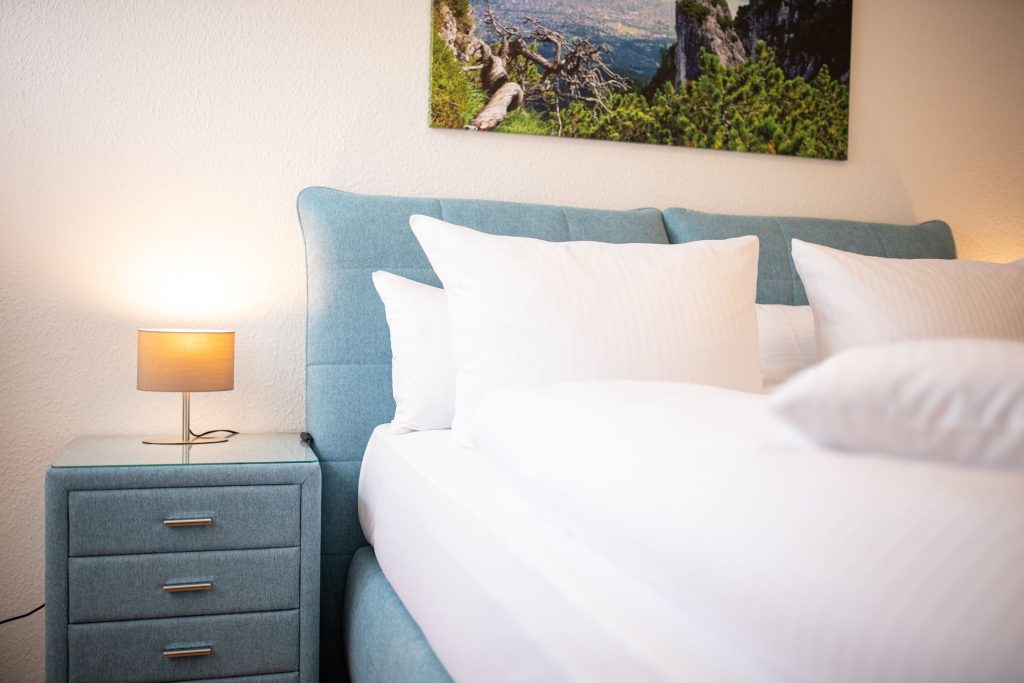 Doppelbett mit Nachttisch in Ferienwohnung in Garmisch-Partenkirchen