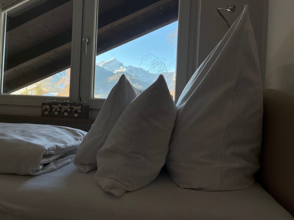 Einzelbett mit einem tollen Blick auf die Berge in Ferienwohnung in Garmisch-Partenkirchen