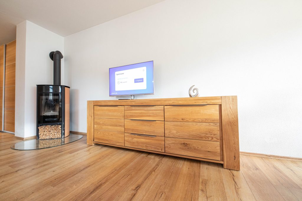 Holzschrank mit Fernseher und Holzkamin in Ferienwohnung in Garmisch-Partenkirchen