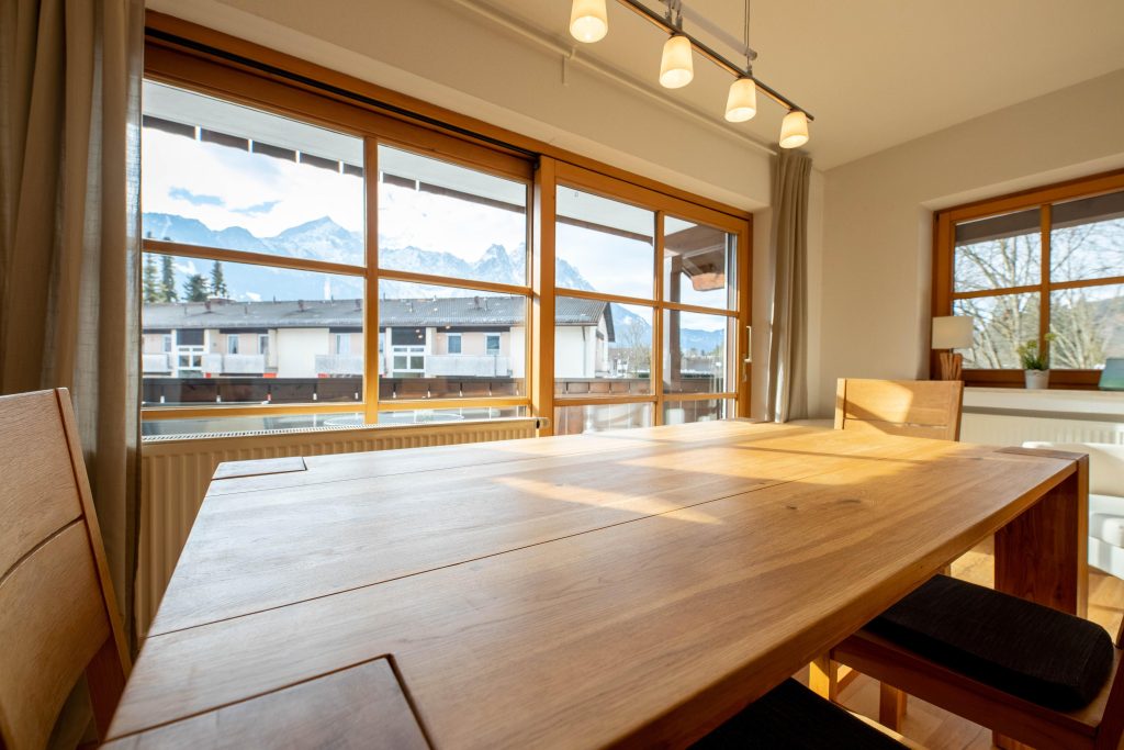 Holztisch mit Deckenlampe und Stühlen in Ferienwohnung in Garmisch-Partenkirchen