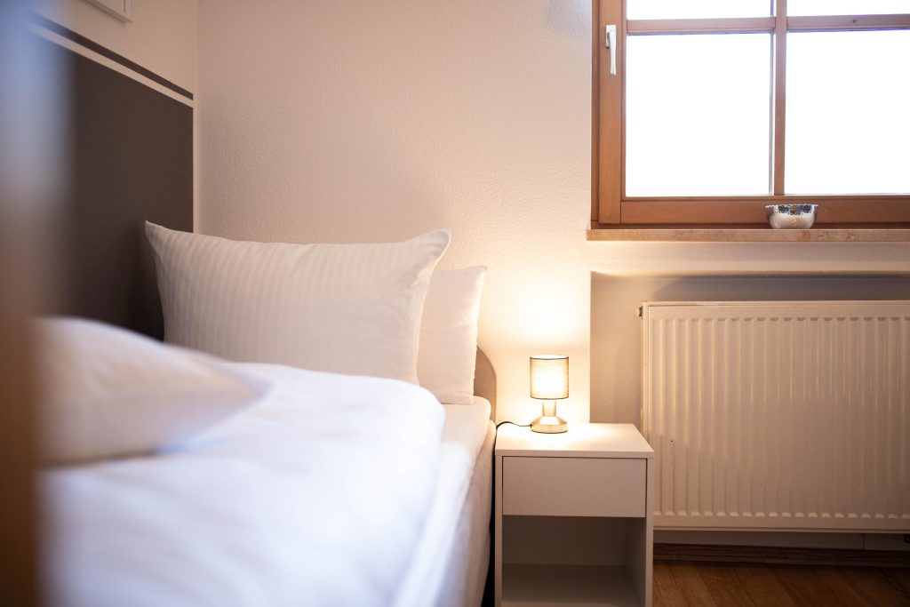 Einzelbett mit kleinem Nachttisch in Ferienwohnung in Garmisch-Partenkirchen