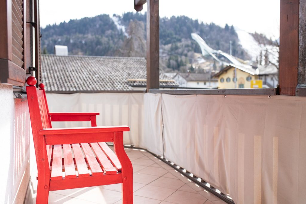 rote Bank auf dem Balkon in Ferienwohnung in Garmisch-Partenkirchen