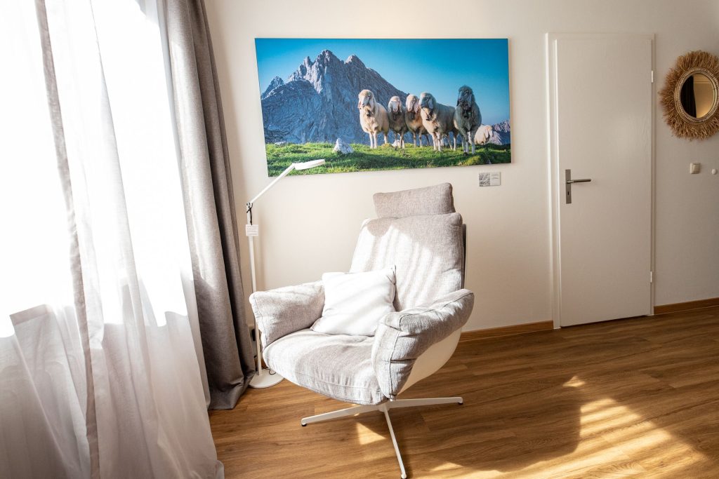 Sessel unter Bild von Schafen in Ferienwohnung in Garmisch-Patenkirchen