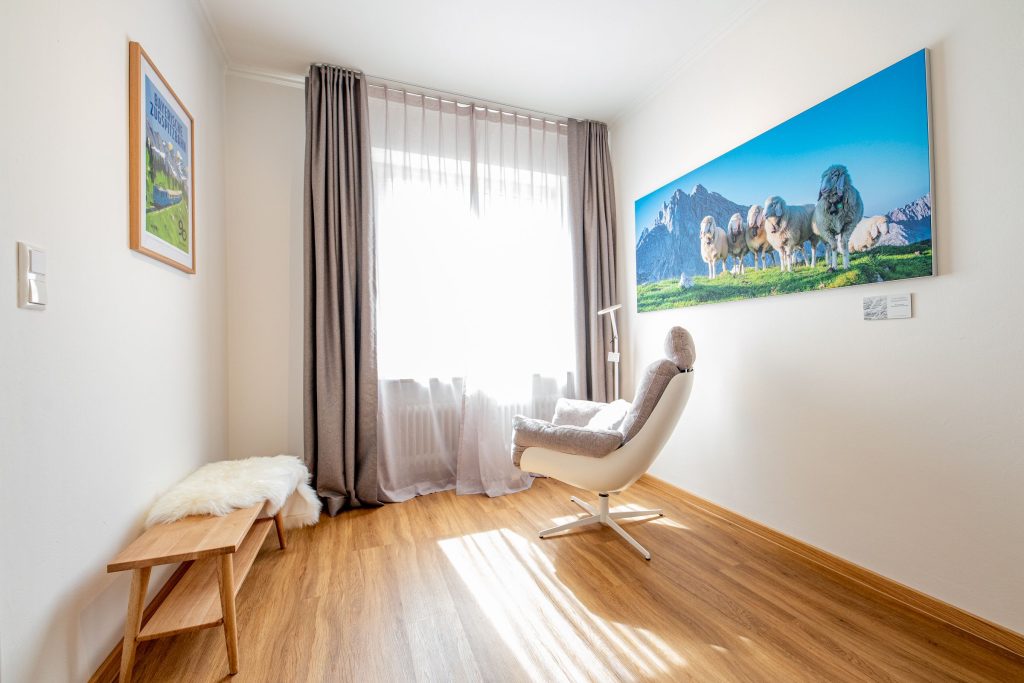 Sessel, Sitzbank und Schafsbild in Ferienwohnung in Garmisch-Patenkirchen