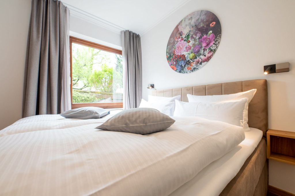 Bett mit rundem Blumenbild in Ferienwohnung in Garmisch-Partenkirchen