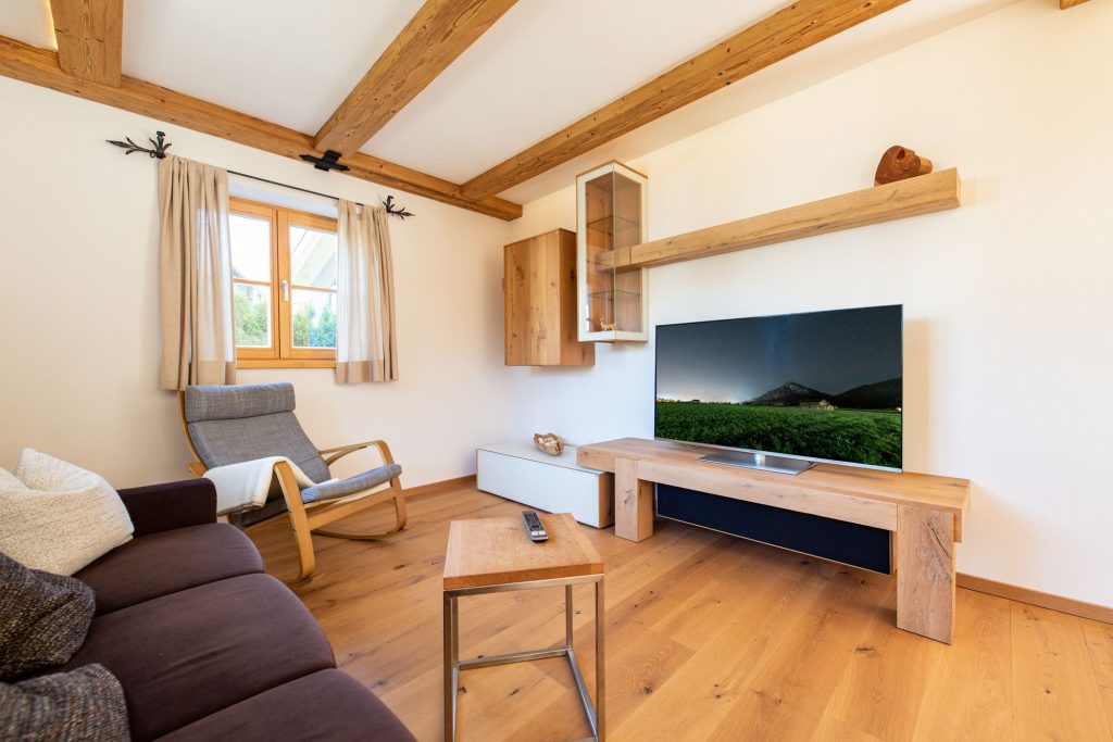 Wohnzimmer mit gemütlichem Sofa und Fernseher in Ferienwohnung in Garmisch-Partenkirchen