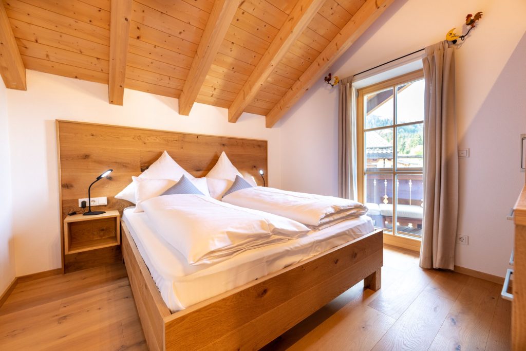 Weiches Bett mit Holzgestell in Ferienwohnung in Garmisch-Partenkirchen