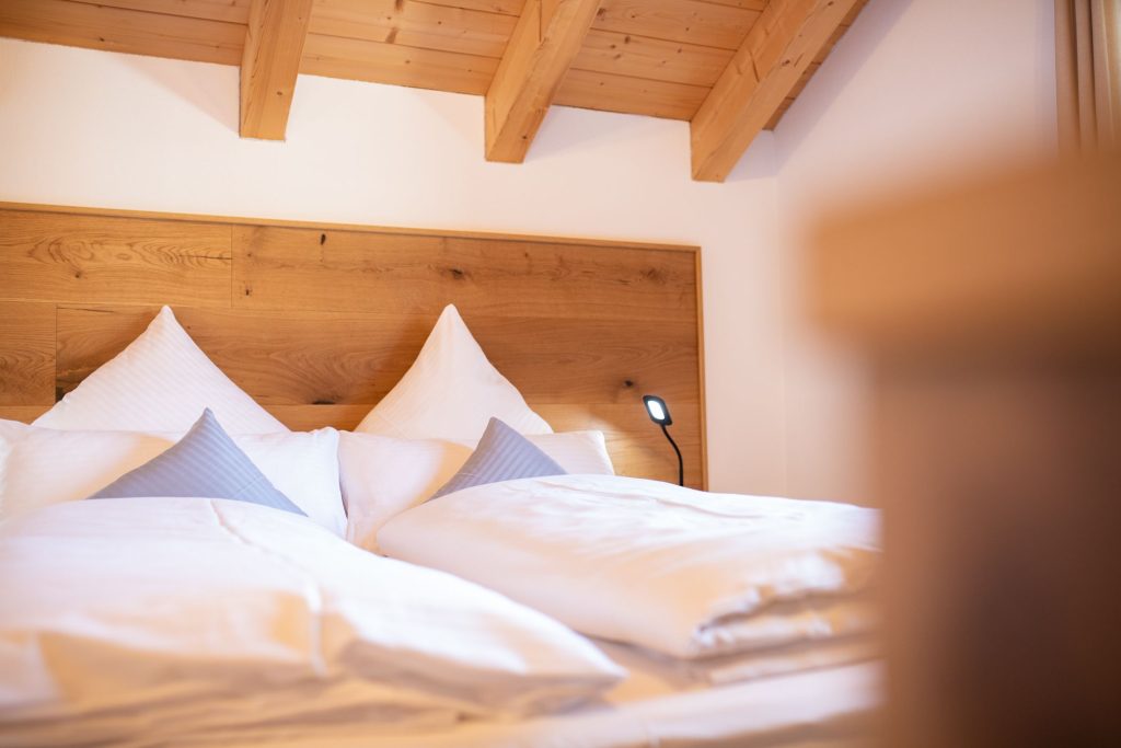 Weiches Bett mit Holzrückwand in Ferienwohnung in Garmisch-Partenkirchen