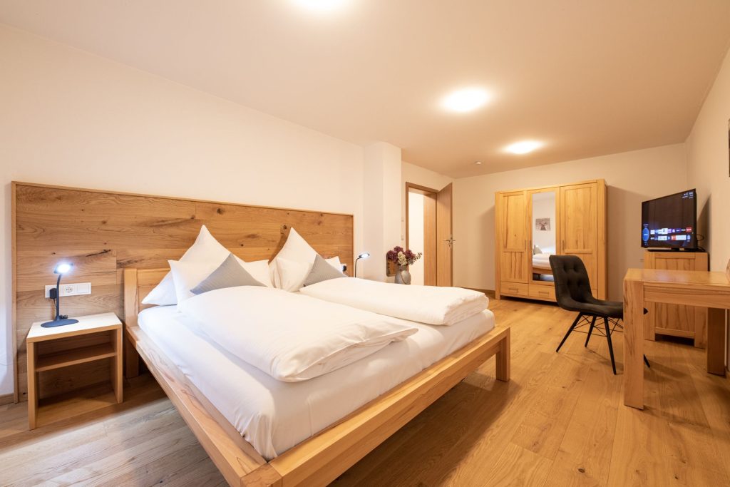 Doppelbett im Schlafzimmer in Holzoptik in Ferienwohnung in Garmisch-Partenkirchen