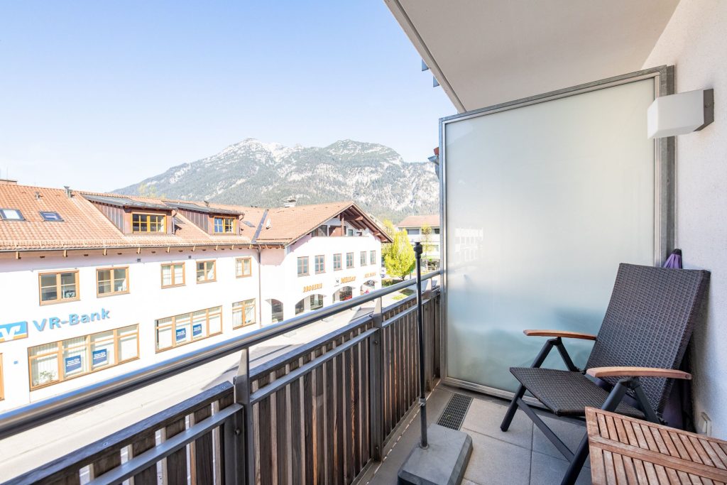 Balkon mit Stühlen und Tisch in Ferienwohnung in Garmisch-Patenkirchen