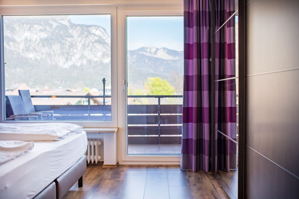 Glastür, großes Fenster und lila Gardinen in Ferienwohnung in Garmisch-Patenkirchen