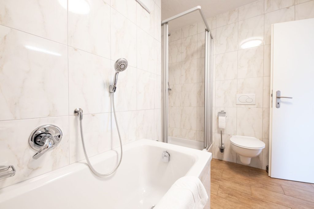 Weißes Badezimmer mit Dusche und Badewanne in Ferienwohnung in Garmisch-Partenkirchen