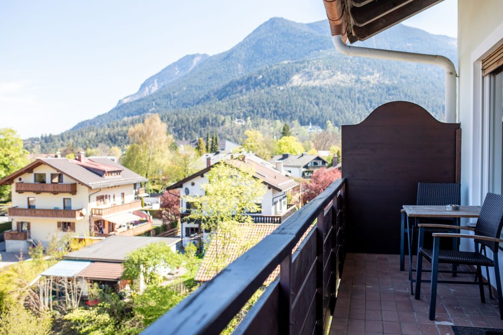 Balkon mit kleinem Tisch und zwei Stühlen in Ferienwohnung in Garmisch-Patenkirchen