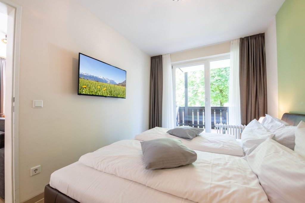 Doppelbett mit Fernseher in Ferienwohnung in Garmisch-Partenkirchen