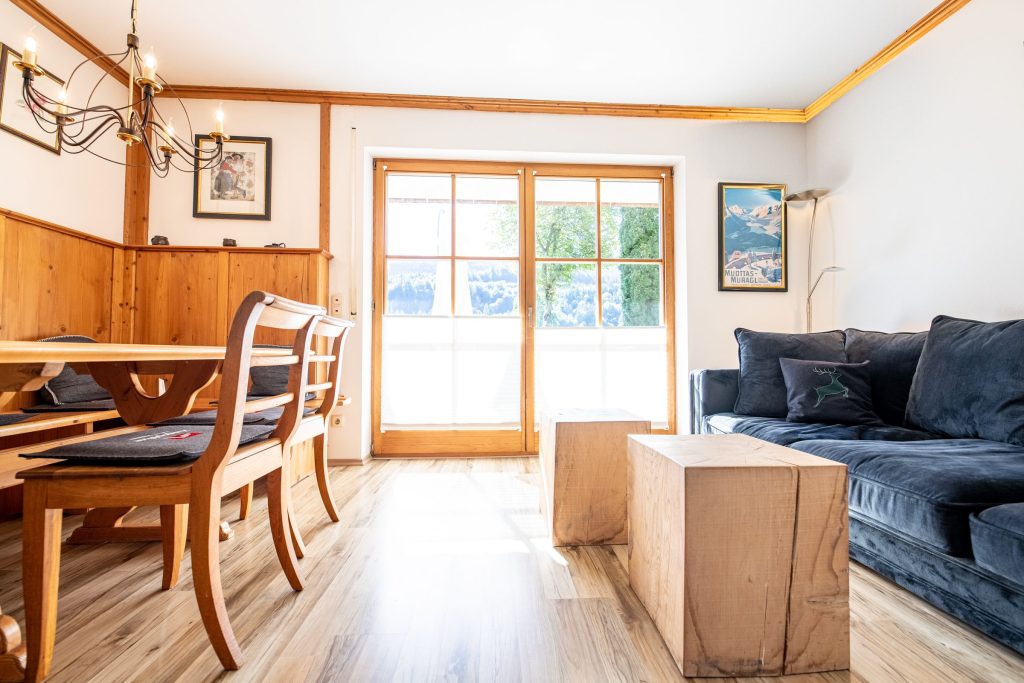 Wohnzimmer mit zwei kleinen Holztischen in Ferienwohnung in Garmisch-Partenkirchen